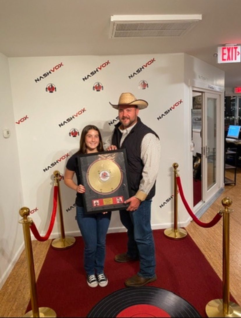 Todd Keller with his daughter Piper holding a gold record at NashVox studios in Nashville